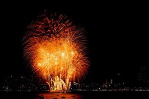 de nombreux feux d'artifice clignotants avec fond de paysage urbain nocturne célèbrent le nouvel an. photo