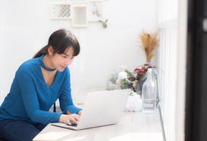 beau portrait asie jeune femme travaillant en ligne sur un ordinateur portable assis au café-restaurant, femme professionnelle indépendante utilisant un ordinateur portable, un concept d'entreprise et de communication. photo