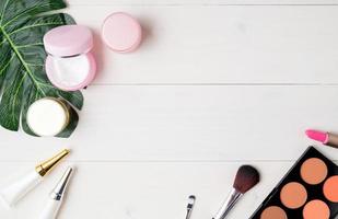 produit cosmétique et de soin de la peau et feuilles vertes sur une table en bois blanc, beauté avec crème de traitement et hydratant sur un bureau en bois, concept de santé et de bien-être, vue de dessus. photo