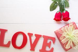 cadeau présent avec fleur rose rouge et coffret cadeau avec ruban arc sur table en bois, 14 février de la journée de l'amour avec concept de vacances romantique, saint valentin, vue de dessus photo