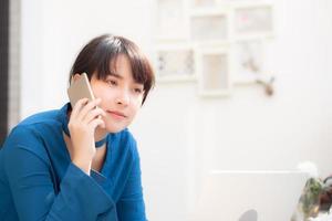 belle jeune femme d'affaires asiatique excitée et heureuse de réussir à travailler avec un ordinateur portable, une fille prenant un téléphone intelligent mobile et un café de travail, concept d'entreprise indépendante de carrière. photo