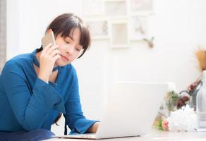 belle jeune femme d'affaires asiatique excitée et heureuse de réussir à travailler avec un ordinateur portable, une fille prenant un téléphone intelligent mobile et un café de travail, concept d'entreprise indépendante de carrière. photo