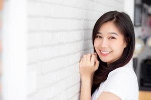 portrait de la belle jeune femme asiatique bonheur debout sur fond gris ciment texture grunge mur brique, femme d'affaires est un sourire sur le béton, concept de gens d'affaires. photo