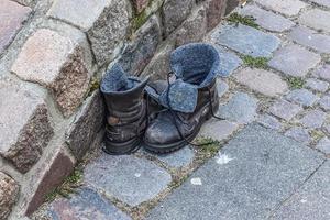 vieille chaussure laissée sur une route d'ashpalt. accessoires élégants et de mode - concept de chaussures pour hommes. photo