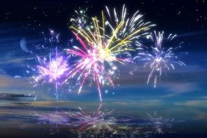 beau feu d'artifice de bonne année dans le ciel avec des reflets sur l'eau photo