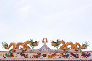 deux stucs chinois dorés sur le toit d'un temple chinois sur le fond du ciel photo