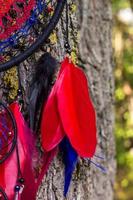 attrape-rêves fait à la main avec des fils de plumes et des cordes de perles suspendues photo