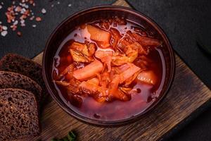 bortsch ukrainien traditionnel. bol de bortsch de soupe de racine de betterave rouge à l'oignon vert photo