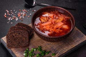 bortsch ukrainien traditionnel. bol de bortsch de soupe de racine de betterave rouge à l'oignon vert photo