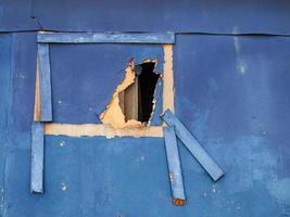 mur de contreplaqué cassé grunge bleu avec un trou à travers avec des planches peintes en bleu pour toile de fond abstraite photo