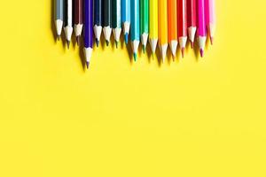 ensemble de crayons colorés sur fond jaune. fond, cadre. retour à l'école, artiste, cours de dessin. papeterie pour la créativité, dessiner photo