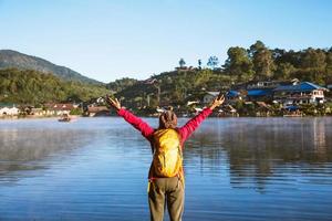 la femme debout près du lac, elle souriait, appréciait et appréciait la beauté naturelle de la brume. photo