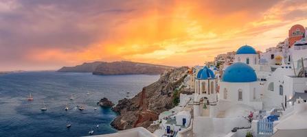 oia au coucher du soleil, île de santorin, grèce. paysage artistique au coucher du soleil avec un beau panorama et des rayons de soleil vue sur la mer. vacances d'été fantastiques et concept de vacances. paysage de nature paisible photo