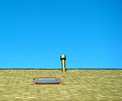 fenêtre de toit et une cheminée sur ciel bleu photo