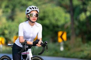 femme heureuse athlète cycliste se prépare à faire du vélo dans la rue, la route, à grande vitesse pour l'exercice passe-temps et la compétition en tournée professionnelle photo