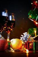 vin rouge en verre clair, arbre de noël et ornement sur table en bois prêt à célébrer.
