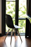 chaise en plastique noir avec pieds en bois dans le salon photo