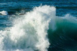 vague se brisant dans la mer faisant de l'écume. photo