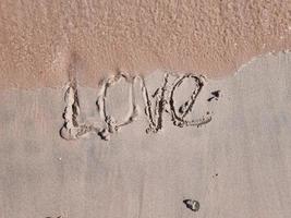 vue rapprochée du mot d'amour sur le sable rose photo