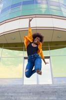 l'heureuse et jeune femme afro-américaine dans la rue s'amusant photo