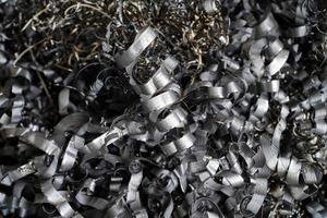 recyclage des déchets d'acier. déchets de copeaux d'aluminium après usinage de pièces métalliques sur un tour cnc. gros plan de copeaux d'acier en spirale torsadée. petite rugosité netteté, photo