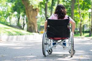 image d'une femme asiatique d'âge moyen assise sur un fauteuil roulant photo