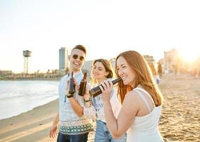 amis buvant de la bière sur la plage photo