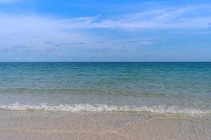 plage ondulée de mer bleu clair avec jour de ciel bleu photo