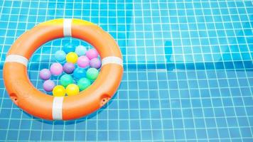 bouée de sauvetage et balles colorées dans la piscine photo