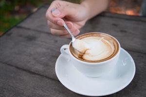 mains de femme avec art latte, tasse à café photo