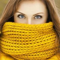 jolie femme dans une écharpe en tricot jaune en regardant la caméra. beaux yeux scrutant. photo