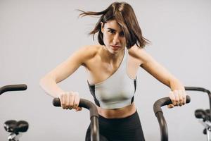 femme crossfit faisant un entraînement cardio intense sur un vélo d'exercice photo