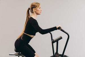 femme crossfit faisant un entraînement cardio intense sur un vélo d'exercice photo