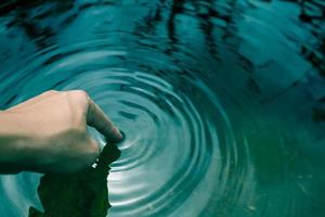 les mains trempées dans l'eau bleue jusqu'aux vagues. photo