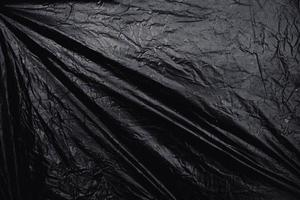 une pellicule de plastique extensible transparente sur fond noir. texture réaliste d'enveloppe en plastique pour la superposition et l'effet. motif en plastique froissé pour un design créatif et décoratif. photo
