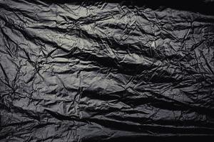 une pellicule de plastique extensible transparente sur fond noir. texture réaliste d'enveloppe en plastique pour la superposition et l'effet. motif en plastique froissé pour un design créatif et décoratif. photo