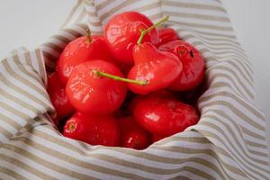 pomme rose rouge dans un panier en osier sur fond blanc photo