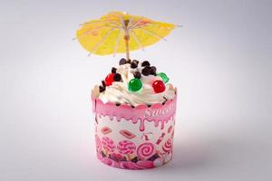 les cupcakes ont un parapluie sur le dessus. sur fond blanc photo