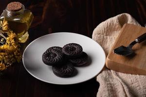 biscuits au chocolat dans une assiette blanche sur un fond en bois foncé. photo