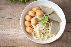 udon, boulettes de crevettes et boulettes de poisson dans une soupe claire cuisine japonaise dans une tasse en porcelaine blanche photo