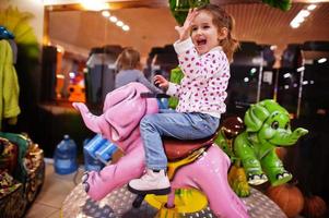 deux sœurs chevauchent un carrousel d'éléphants dans un centre pour enfants amusant. photo