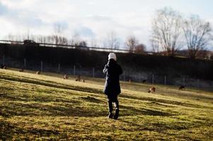 jeune garçon faisant une photo de chevreuils dans la prairie au début du printemps.