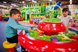 les enfants jouent avec du sable cinétique dans un centre de jeux intérieur. photo