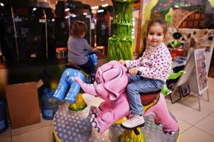 deux sœurs chevauchent un carrousel d'éléphants dans un centre pour enfants amusant. photo