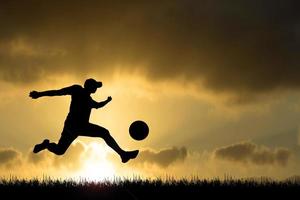 silhouette de joueurs de football dans la soirée. concept de football est populaire partout dans le monde. photo