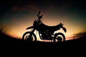 parc de silhouette de motocross moto touristique sur la montagne le soir. concept de voyage d'aventure photo