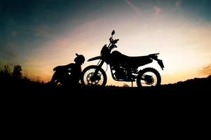 silhouettes masculines et vélos de motocross de tourisme. parc pour se détendre à la montagne le soir. concept de voyage d'aventure et de loisirs photo