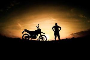 silhouettes masculines et vélos de motocross de tourisme. parc pour se détendre à la montagne le soir. concept de voyage d'aventure et de loisirs photo