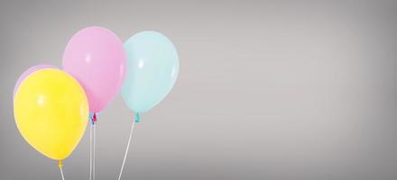 Ballons à l'hélium de vacances isolés sur fond gris, concept d'anniversaire photo