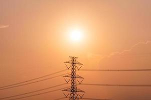 poteau haute tension, tour de transmission avec ligne électrique au coucher du soleil photo